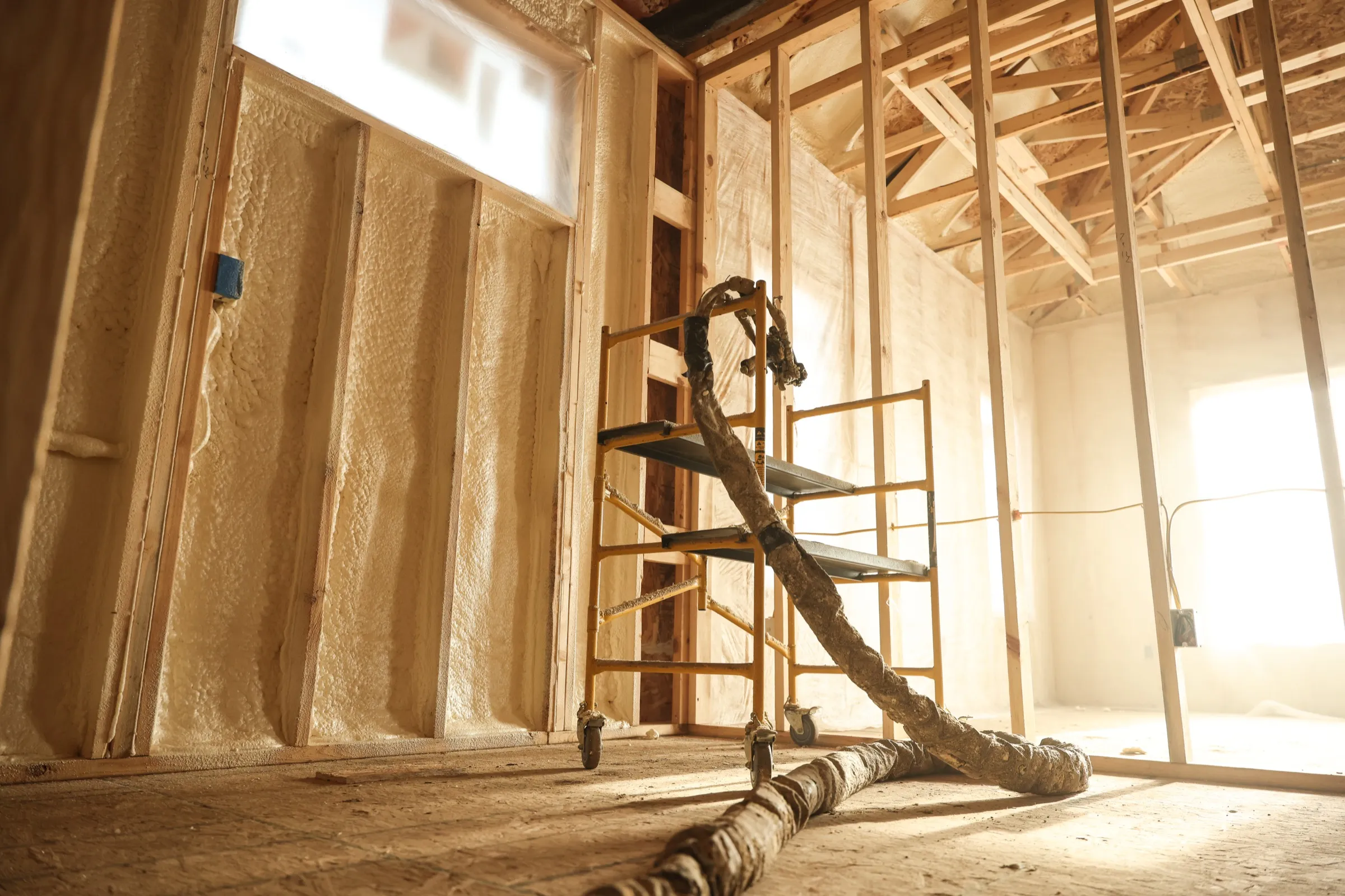 Installer applying spray foam with professional equipment